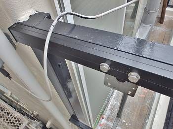 アルミ材を取付けたフェンス。 ボルトで固定された手前の部分のみが新しいアルミ材です。