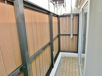 施工後のバルコニー内です。 木目調のお洒落な目隠しです。 以前とは異なり樹脂製なので、腐朽する恐れはなくなりました。