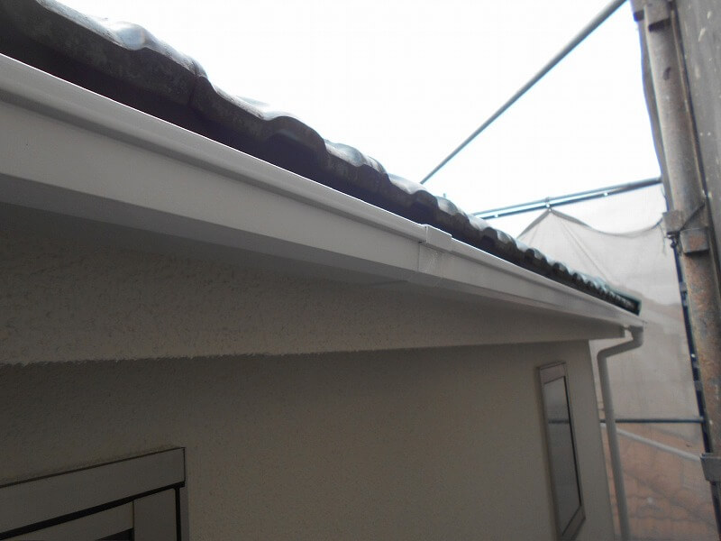 塀にはサビ汚れや伝い水の汚れが多くついており、よく見ると笠木板金の下に白いものが出ています。