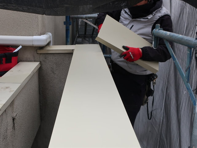 塀の傷んだ笠木板金を新しい板金で覆って雨水が入らないようにしています。