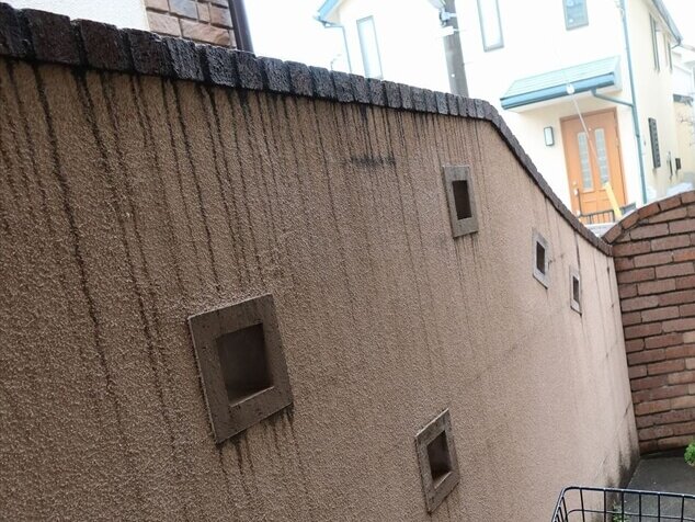 塀は、上部のタイルの隙間から汚れた水がしたたるため線状に汚れがついています。