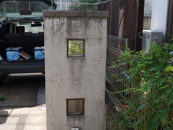 門扉はてっぺんにあるタイル状の石の間から水が滴り落ちるため、線上の汚れがついています。