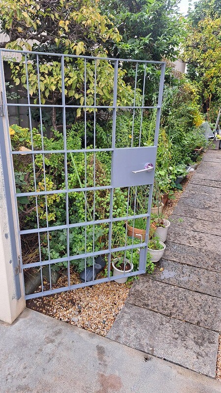 仕上げの塗装は、門扉をしっかりと開いて塗り忘れがないか確認しながらの作業です。（エスケー化研 クリーンマイルドシリコン 調色）