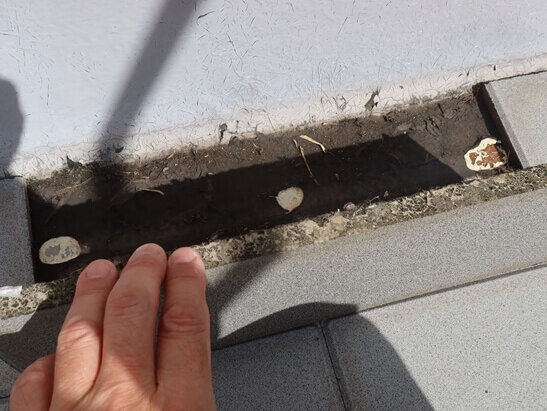 床面のタイルを持ち上げてみたところ、防水のトップコートがはがれているところがありました。