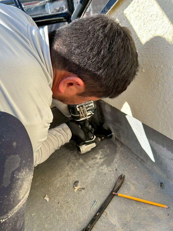 ベランダの床の防水をやり直すため、排水口の位置を調整しています。