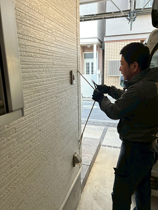 外壁のシールを交換するため、古いシールを取り除いています。